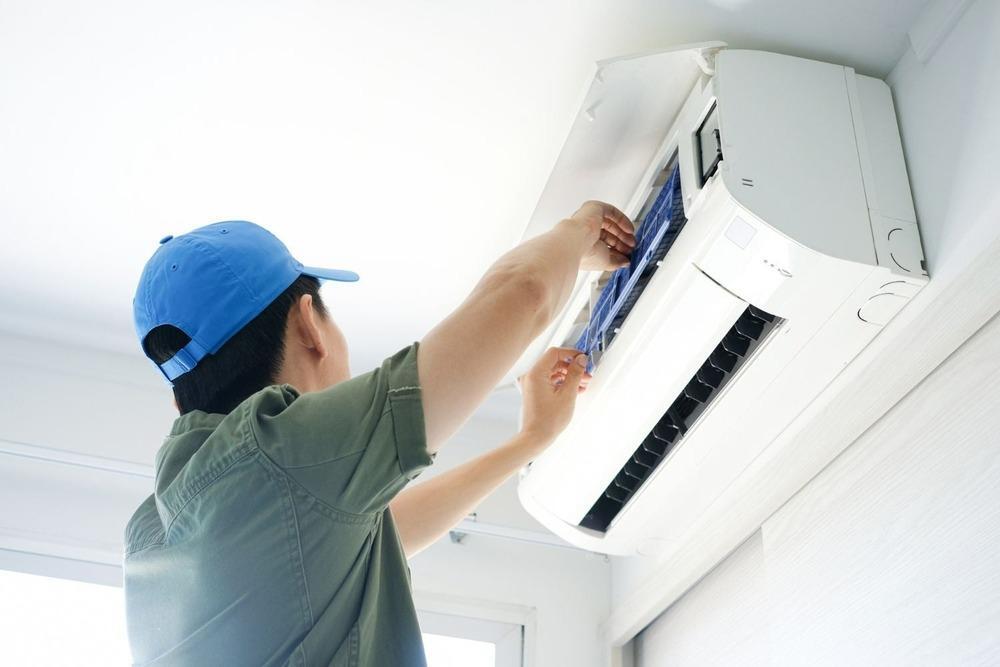 Technician servicing a wall-mounted air conditioner